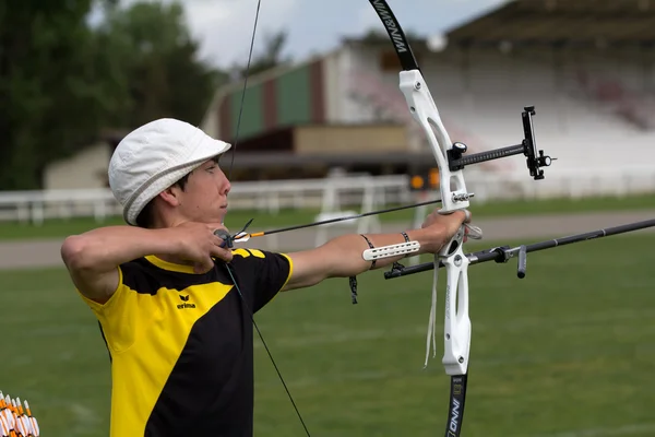 Un competidor está listo para disparar con un arco y una flecha . — Foto de Stock