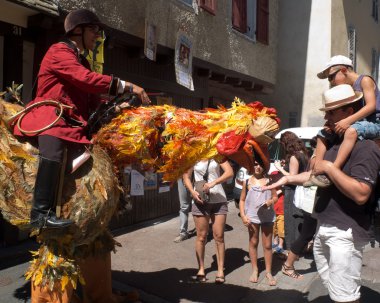 Spectators looking at a very big and strange cock in the street .