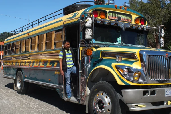 Mann auf dem Trittbrett eines farbigen Busses. — Stockfoto