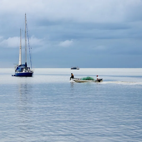 Yeşil ağları ile küçük beyaz balıkçı teknesi. — Stok fotoğraf
