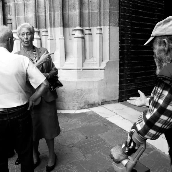 ミサの終わりに、古い乞食は大聖堂の出口で配布資料を求める . ストックフォト