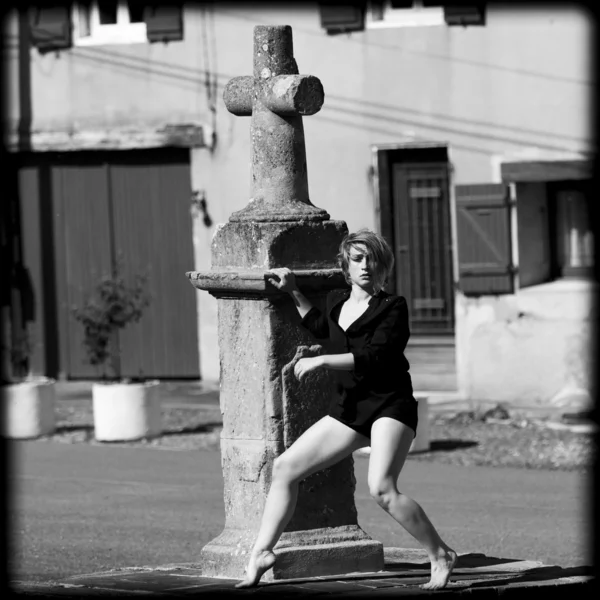 Bailarina rubia descalza al pie de una cruz en el camino . — Foto de Stock