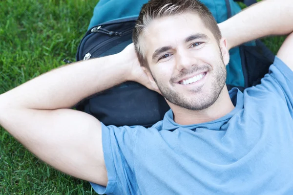 Retrato de un estudiante universitario acostado en la hierba — Foto de Stock