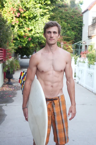 En aktiv ung man med en surfbräda — Stockfoto