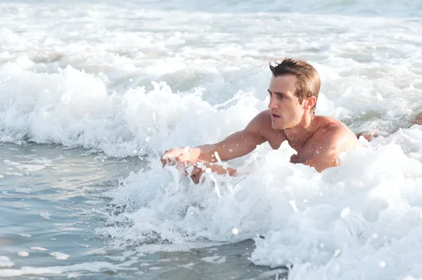 Jeune homme actif surfant dans l'océan — Photo