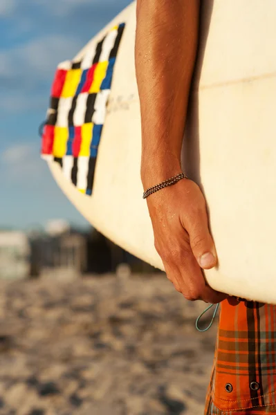 Primer plano de un surfista sosteniendo una tabla de surf —  Fotos de Stock