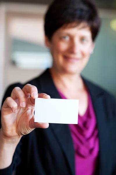 Retrato de uma empresária madura segurando um cartão de visita — Fotografia de Stock