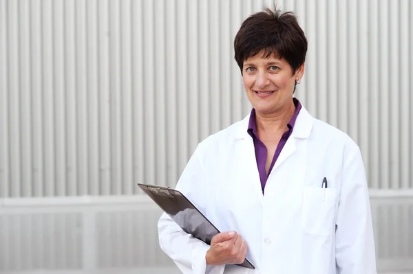 Olgun profesyonel kadın giyinmiş stetoskop içinde gülümseyen — Stok fotoğraf