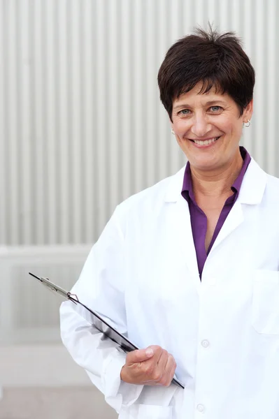 Χαμογελώντας ώριμη επαγγελματική γυναίκα ντυμένη με labcoat — Φωτογραφία Αρχείου