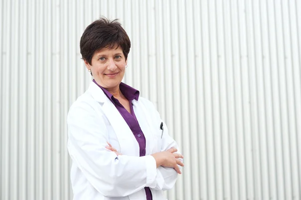 Smiling mature professional woman dressed in labcoat — Stock Photo, Image