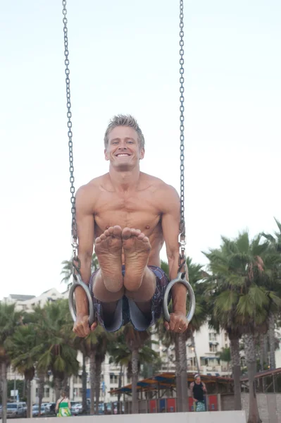 Jeune athlète en forme faisant de la gymnastique sur les anneaux — Photo