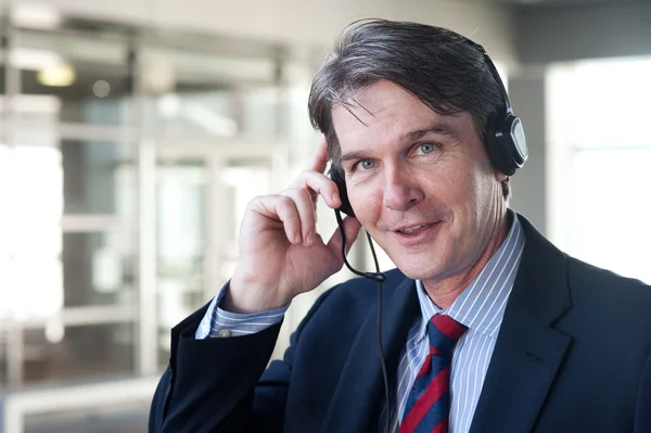 Portrait of a mature businessman with headset — Stock Photo, Image