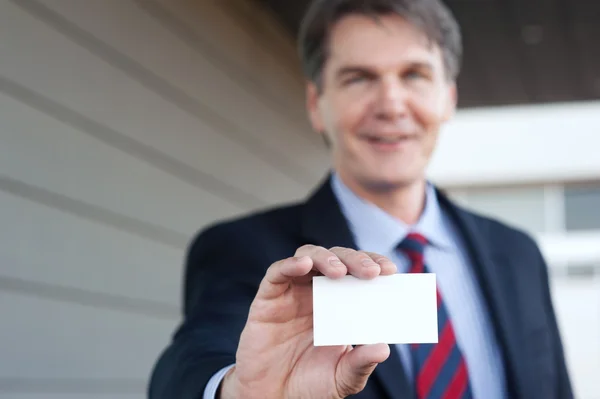 Mature businessman holding business card — Stock Photo, Image