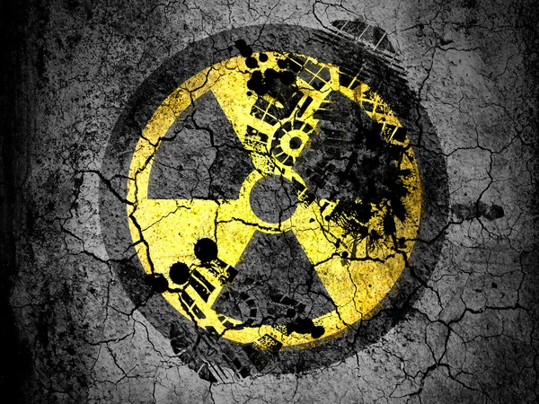 Nuclear radiation symbol painted on cracked ground with vignette with dirty oil footprint over it — Stock Photo, Image