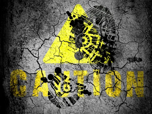Caution sign painted on cracked ground with vignette with dirty oil footprint over it — Stock Photo, Image