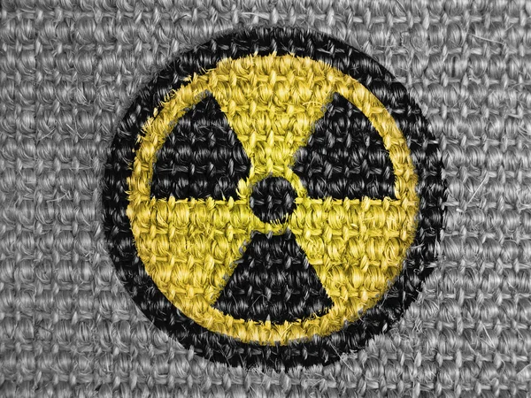 Nuclear radiation symbol painted on grey fabric — Stock Photo, Image