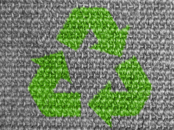 Recycle symbol painted on grey fabric
