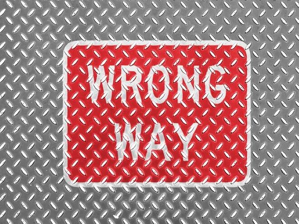 Wrong way road sign painted on metal floor
