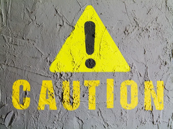 Caution sign painted on wall — Stock Photo, Image