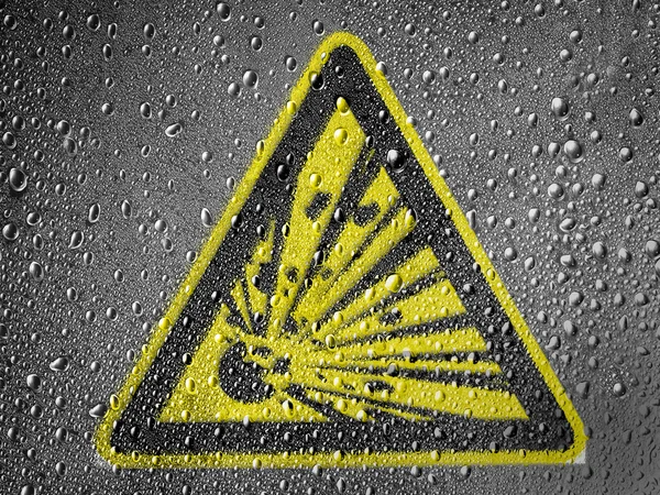 雨の滴で覆われていない金属面に描かれた爆発性の記号 — ストック写真