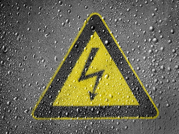 Электрический ударный знак, окрашенный на металлической поверхности, покрытой капельками дождя — стоковое фото