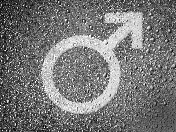 Символ женщины, нарисованный на металлической поверхности, покрытой капельками дождя — стоковое фото