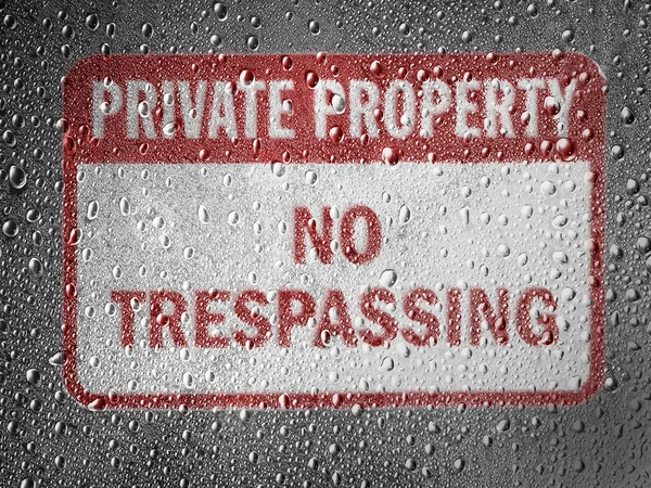 No trespassing sign painted on metal surface covered with rain drops — Stock Photo, Image