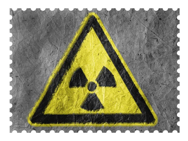 Nuclear radiation sign drawn on paper postage stamp — Stock Photo, Image