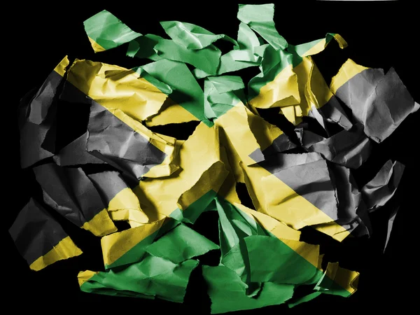 Jamaica vlag geschilderd op stukjes gescheurd papier op zwarte achtergrond — Stockfoto