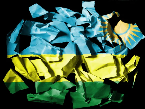 Ruanda flag painted on pieces of torn paper on black background — Stock Photo, Image
