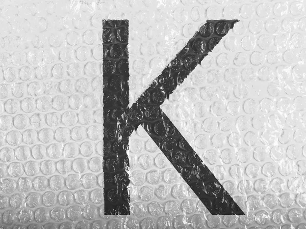 K letter painted on bubblewrap — Stock Photo, Image