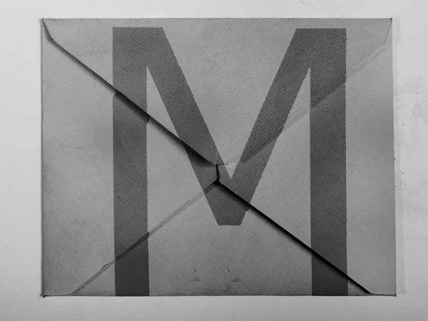 M letter painted on grey envelope — Stock Photo, Image