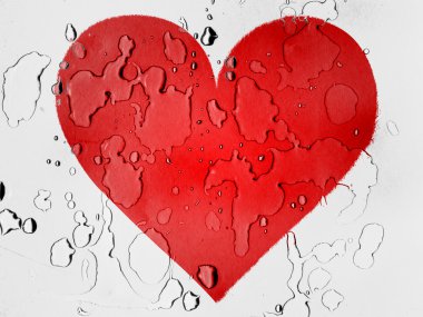 Red Heart symbol painted on covered with water drops