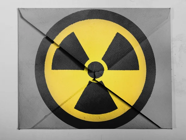 Símbolo de radiação nuclear pintado sobre envelope cinzento — Fotografia de Stock