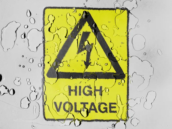 High voltage sign drawn at covered with water drops — Stock Photo, Image