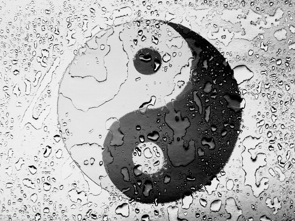 The Ying Yang sign painted on covered with water drops