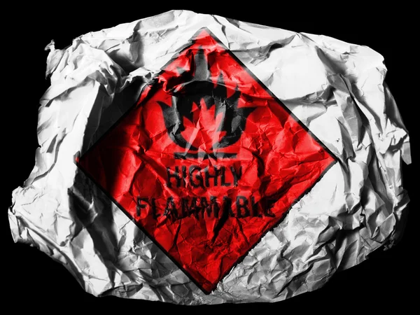 Highly flammable sign drawn on painted on crumpled paper on black background — Stock Photo, Image