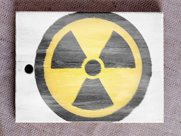 Nuclear radiation symbol painted on painted over wooden board — Stock Photo, Image