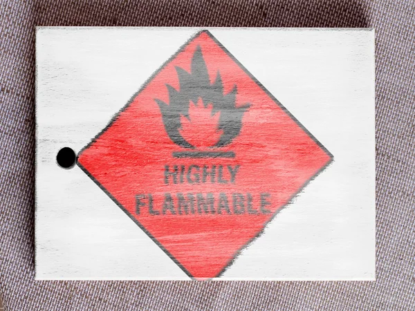 Highly flammable sign drawn on painted over wooden board — Stock Photo, Image