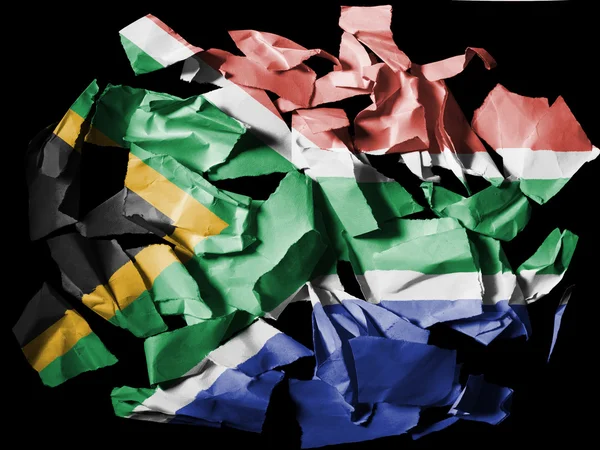 Bandera sudafricana pintada sobre trozos de papel desgarrado sobre fondo negro —  Fotos de Stock