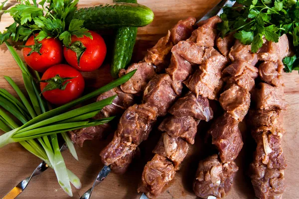 Raw kebab with onion on wooden board Stock Picture