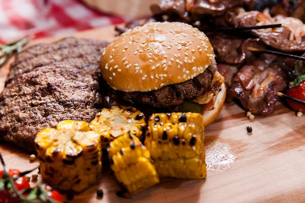 Set of grilled meat and burger on wooden board — Stock Photo, Image