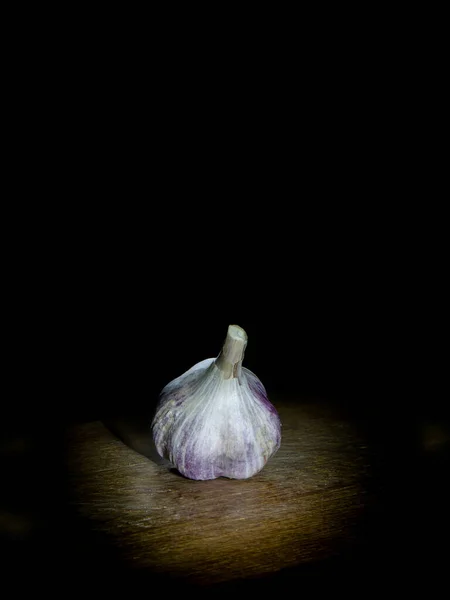 Garlic on wooden board on dark background Royalty Free Stock Photos
