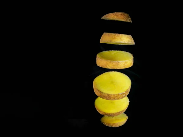 Sliced potato floating on black background Stock Image