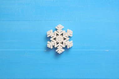 Yılbaşı tatili için kar taneleri olan mavi bir arkaplan.