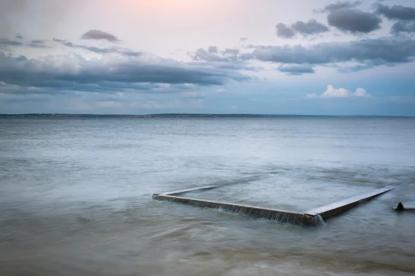 Seascape. The composition of nature. Concrete slab in the water.