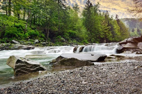 Áspero rio de montanha com espuma branca flui entre as rochas e t — Fotografia de Stock