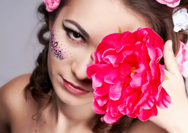 Chica con un hermoso rostro y flores en el pelo —  Fotos de Stock