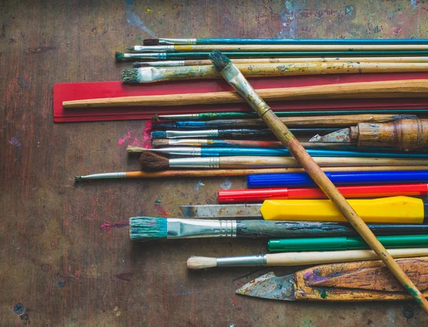 Set of paint brushes and office supplies on the table — Stock Photo, Image