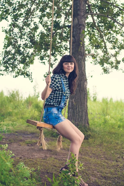 Retrato de guapa morena balanceándose sobre cuerda columpio —  Fotos de Stock